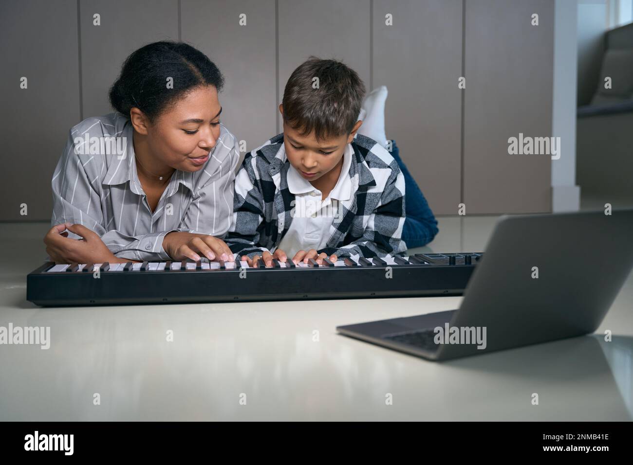 Mom teaches teen son to play digital piano Stock Photo Alamy