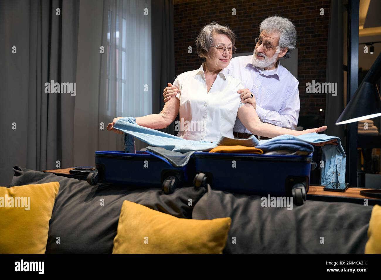 Old woman folds clothes in trolley bag Stock Photo Alamy