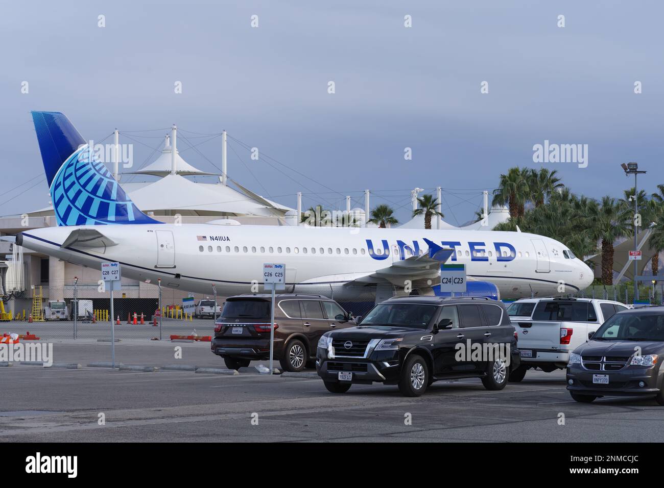 Palm Springs International Airport, California. United Airlines Airbus A320-232 aircraft with registration N411UA and rental vehicles shown parked. Stock Photo