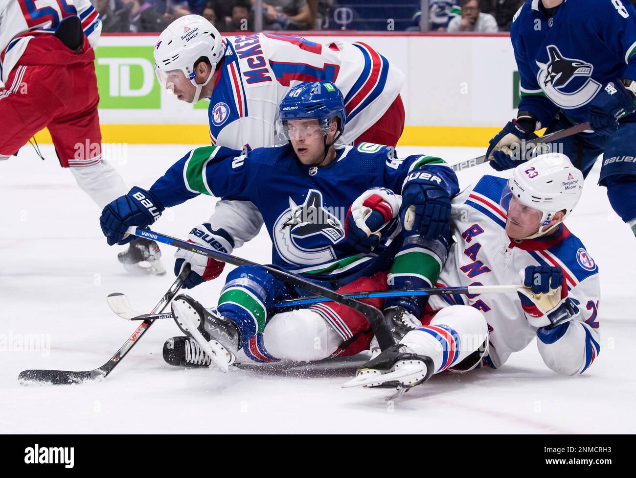 Vancouver Canucks' Elias Pettersson, center, collides with New York