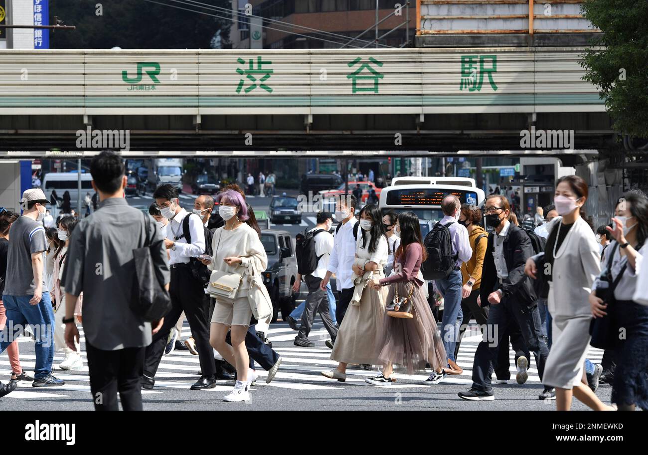 People cross the Shibuya Scramble Crossing in front of Shibuya Station ...