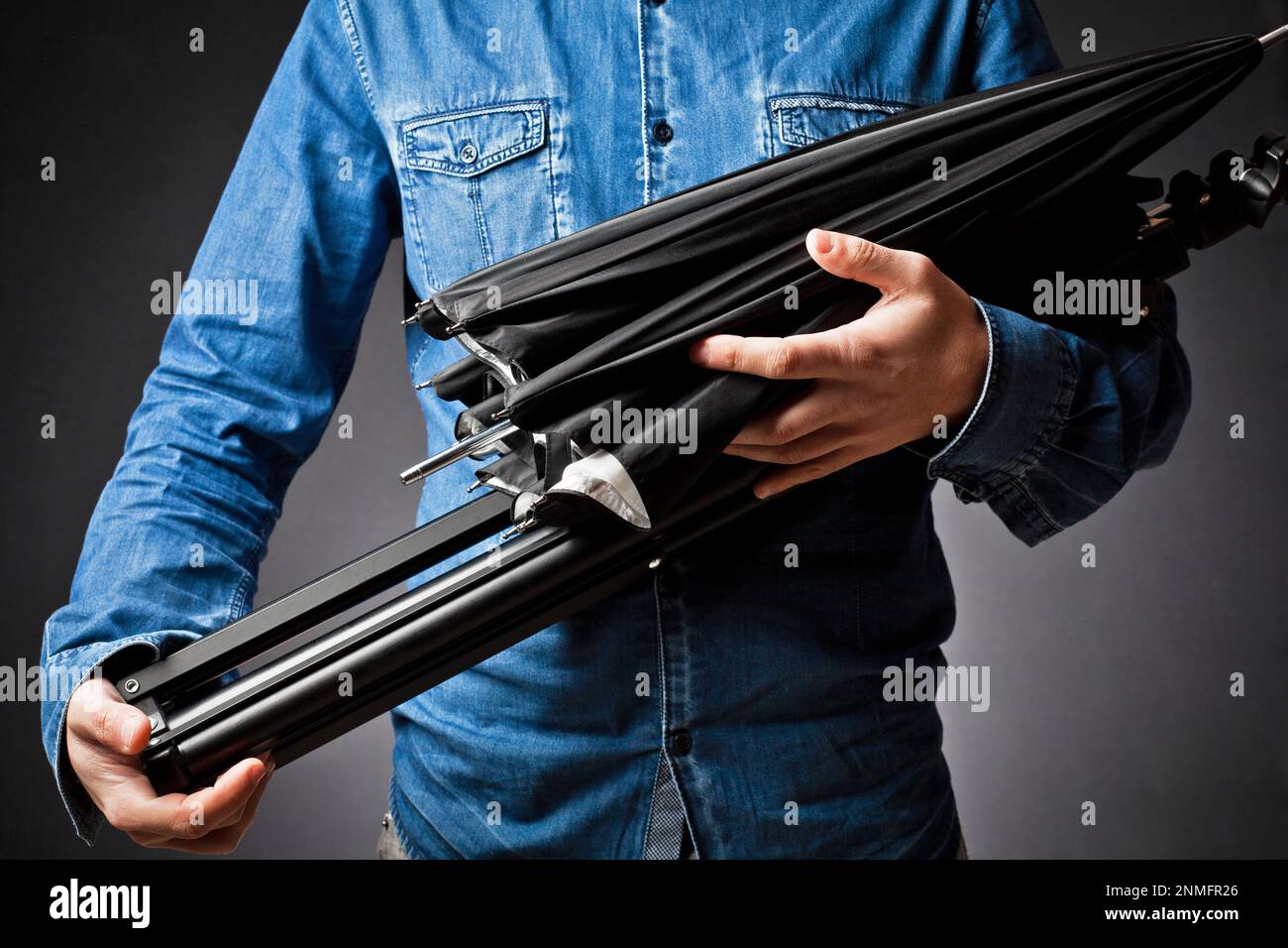 Work of photographer and assistant with various accessories umbrella