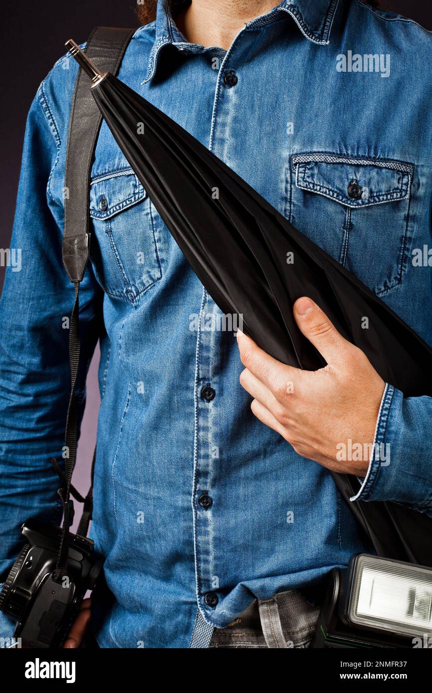 Work of photographer and assistant with various accessories: flash, umbrella and camera Stock Photo