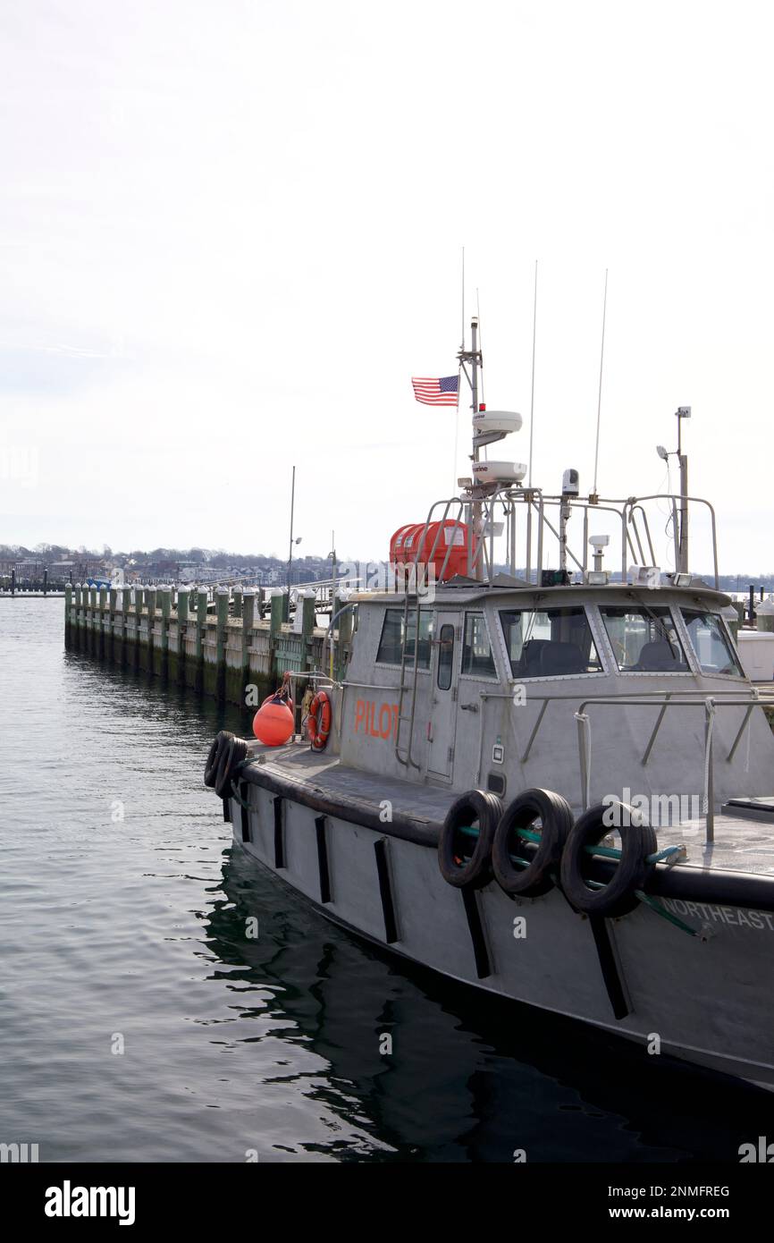 Boat with words PILOT on outside. Docked in Newport Harbor on a cloudy, winter day in Rhode Island, USA. Stock Photo