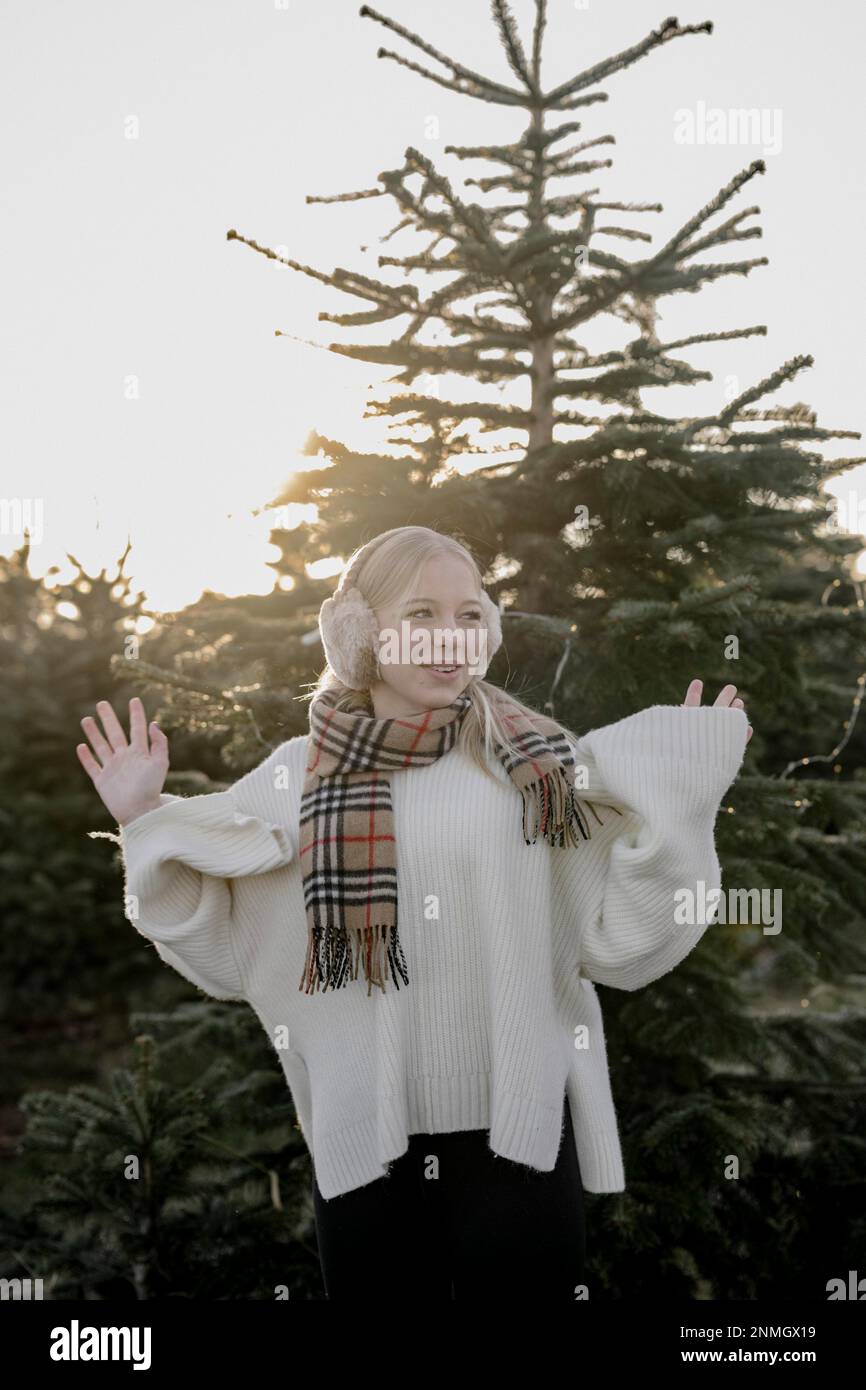 Teenage girl in front of fir trees Stock Photo