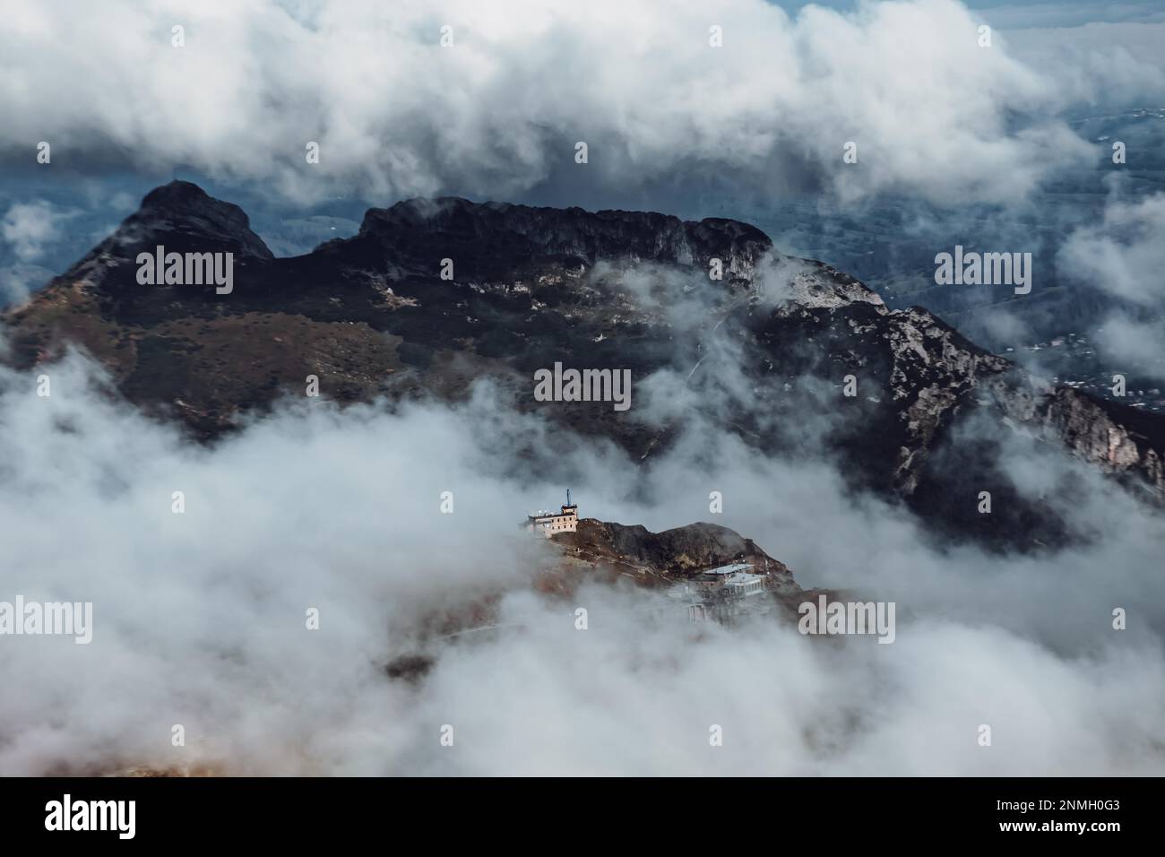 Meteo station on Kasprowy Wierch and Giewont summit on background, exposed by clouds for a fraction of a second, Tatra Mountains, Poland Stock Photo