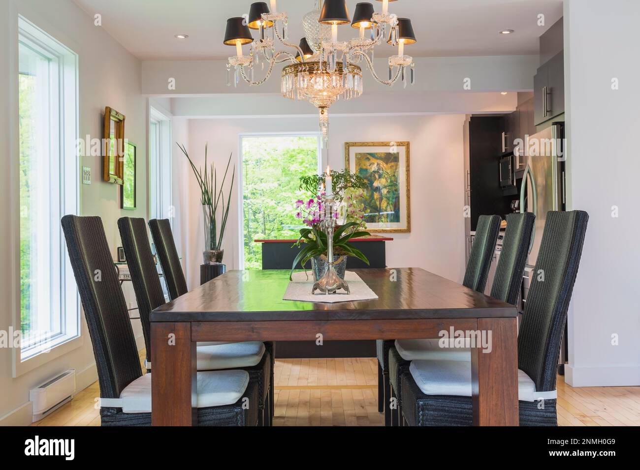 Walnut colored wooden dining table with black high back wicker chairs