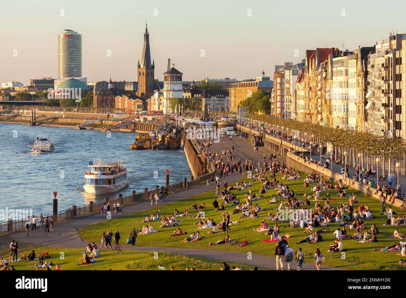Outdoor sunny view of crowd of people sit, hang out and enjoy beautiful ...