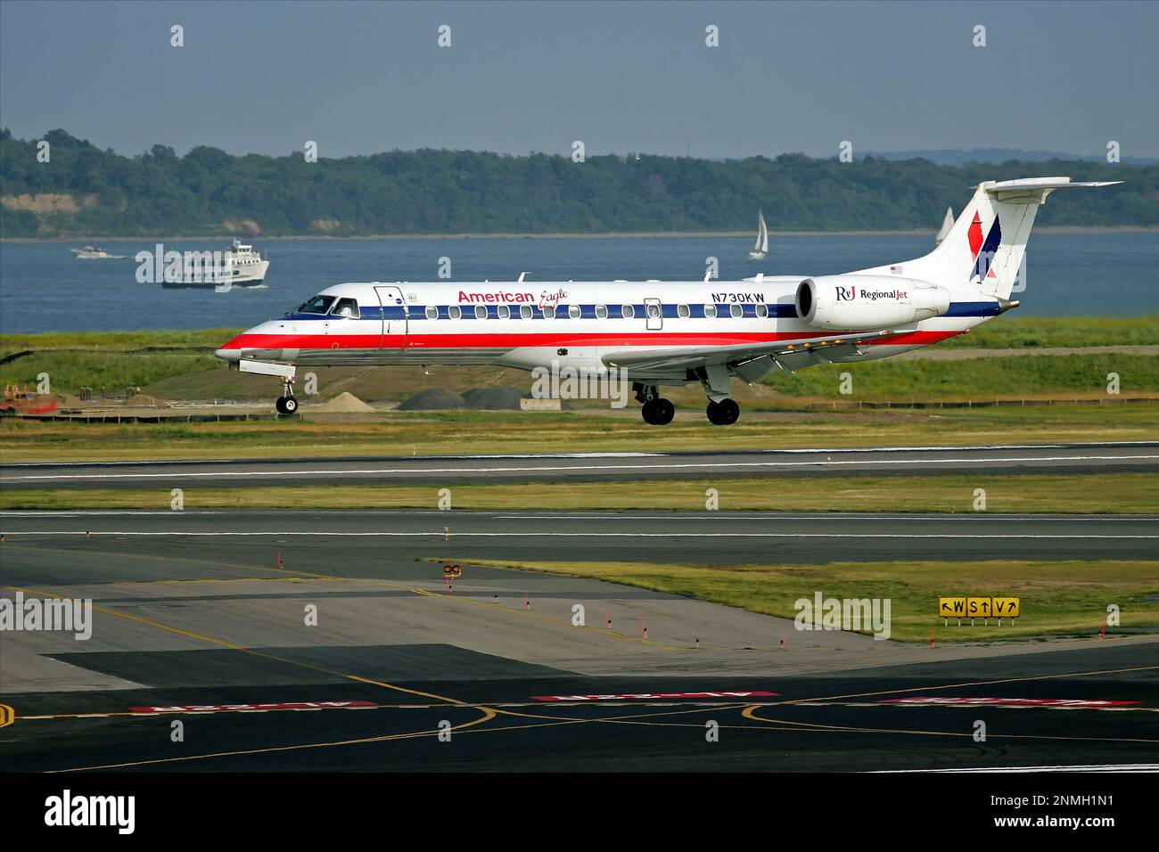 American Eagle airlines regional jet plane landing at airport, Boston Harbor background Stock Photo