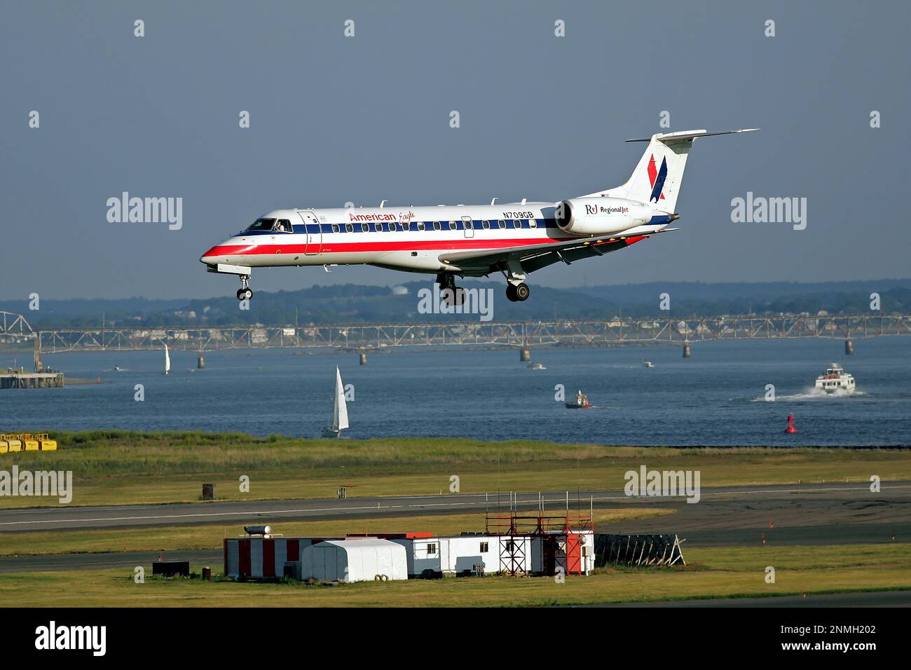 American Eagle airlines small jet plane arrival airport landing over Boston harbor Stock Photo