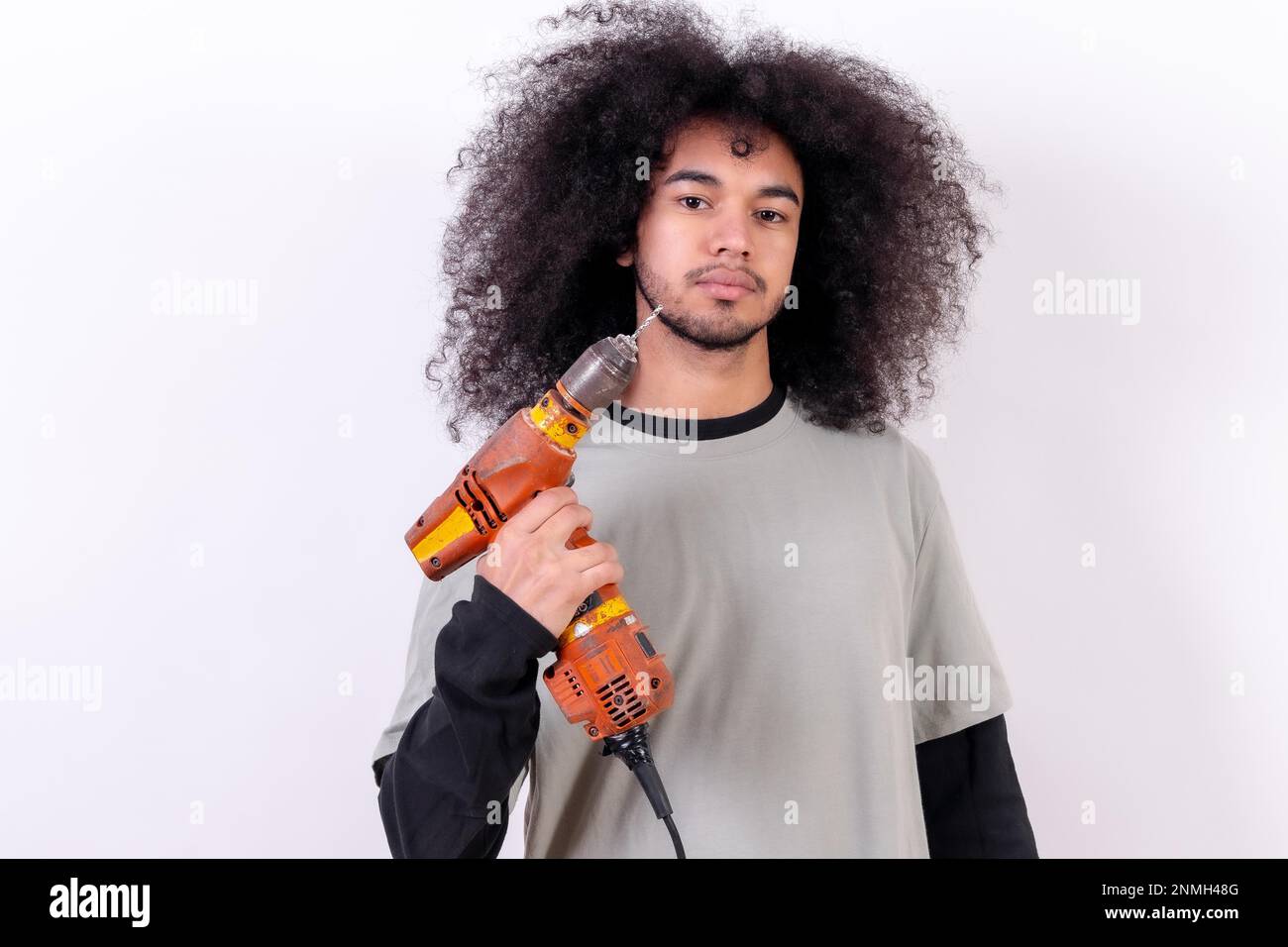 Portrait of the technician with the drill. Young man with afro hair on