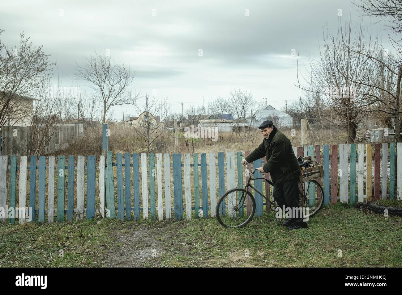 A man on his bicycle on his way home, carrying consecrated water after the blessing on Epiphany, Kotlyareve was heavily destroyed during the Russian Stock Photo
