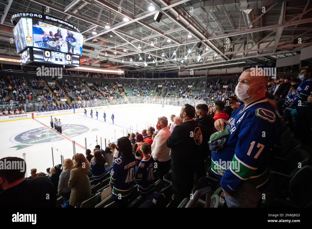 Fans stand as members of the Stolo Nation drum and perform a welcome song before the Vancouver Canucks and the Calgary Flames play a preseason NHL hockey game in Abbotsford, British Columbia,