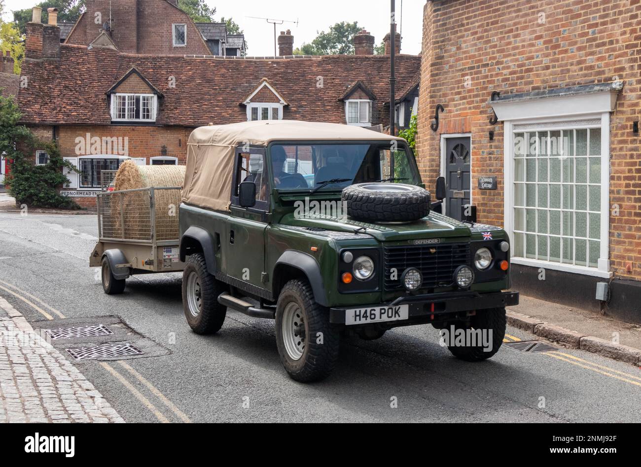 Landrover Defender pulling truck with a bale of hay, Chesham, Buckinghamshire, England Stock Photo