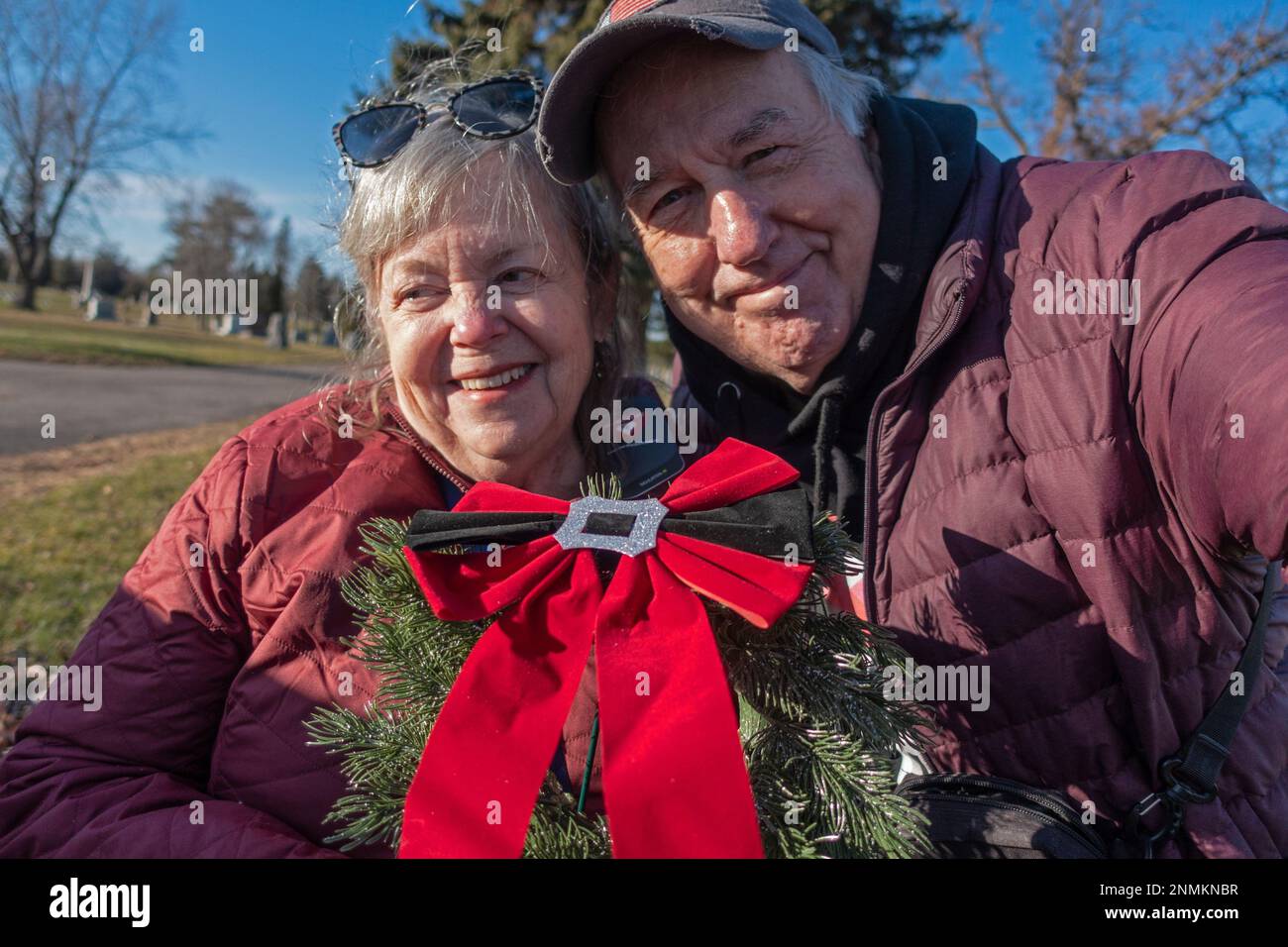 Photographers Mary and Steve Skjold decorating parents graves with wreaths at the Crystal Lake Cemetery. Minneapolis Minnesota MN USA Stock Photo