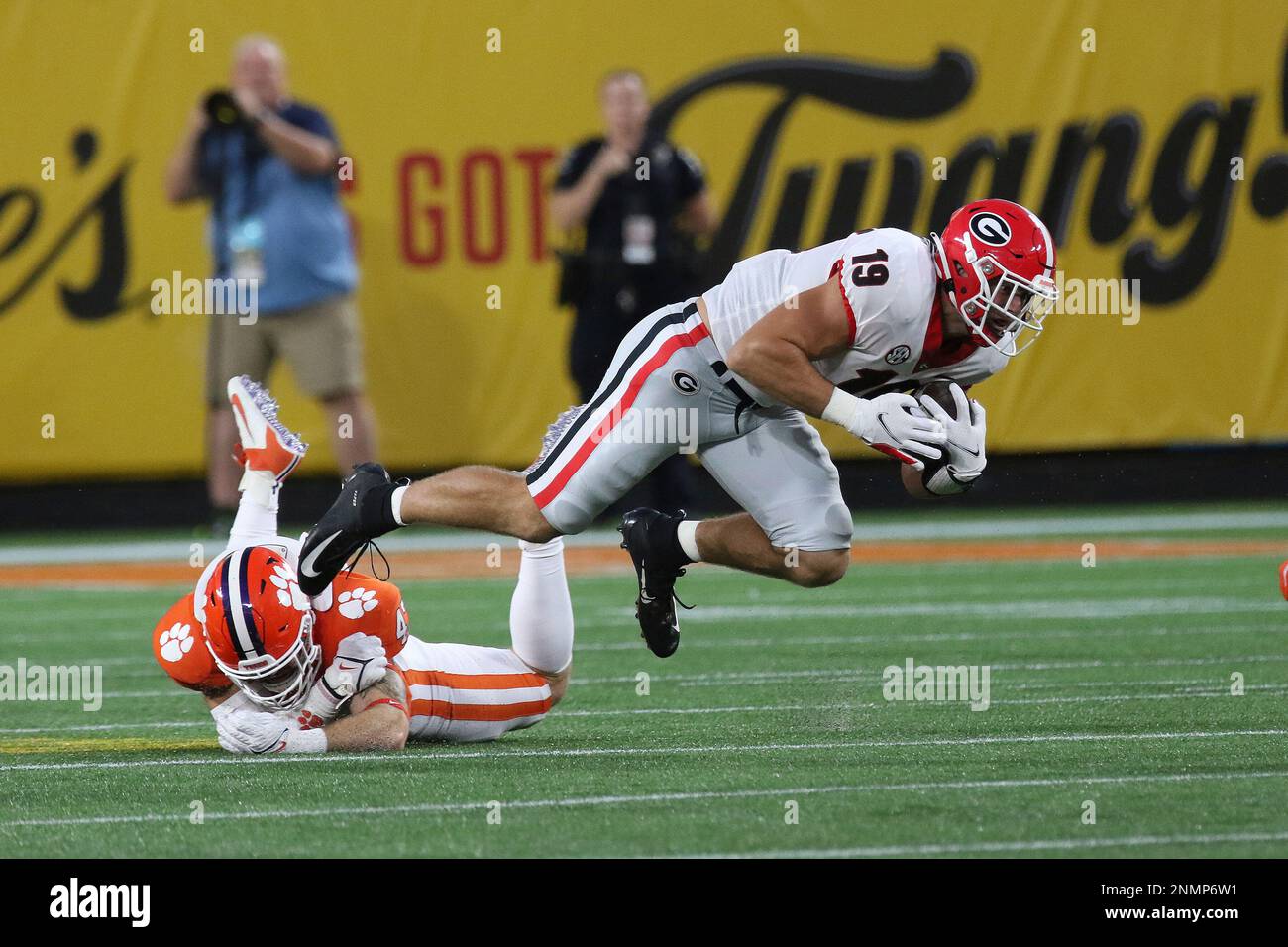 CHARLOTTE, NC - SEPTEMBER 04: James Skalski (47) linebacker of Clemson  trips up Brock Bowers (19) tight end of Georgia after making a catch during  the Duke's Mayo Classic college football game