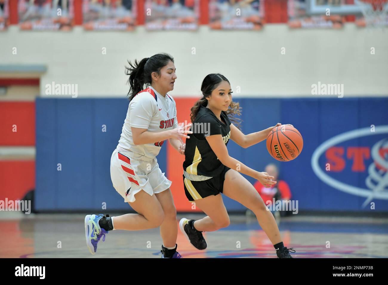 USA. Player attempting to drive around an opponent during a high school varsity basketball game. Stock Photo
