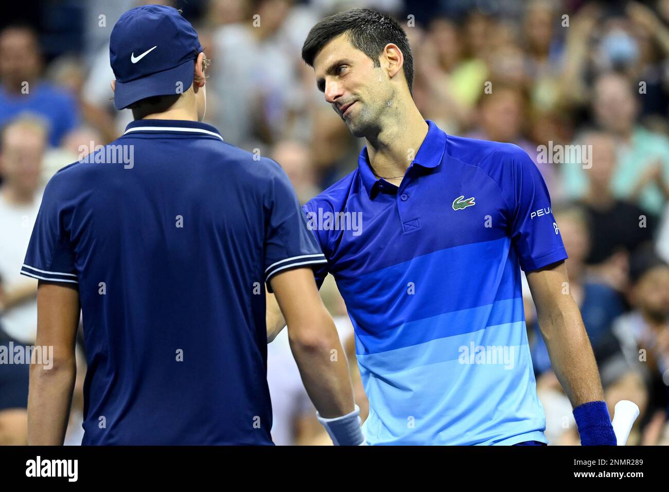 Holger Vitus Nodskov Rune and Novak Djokovic shake hands after a Men's