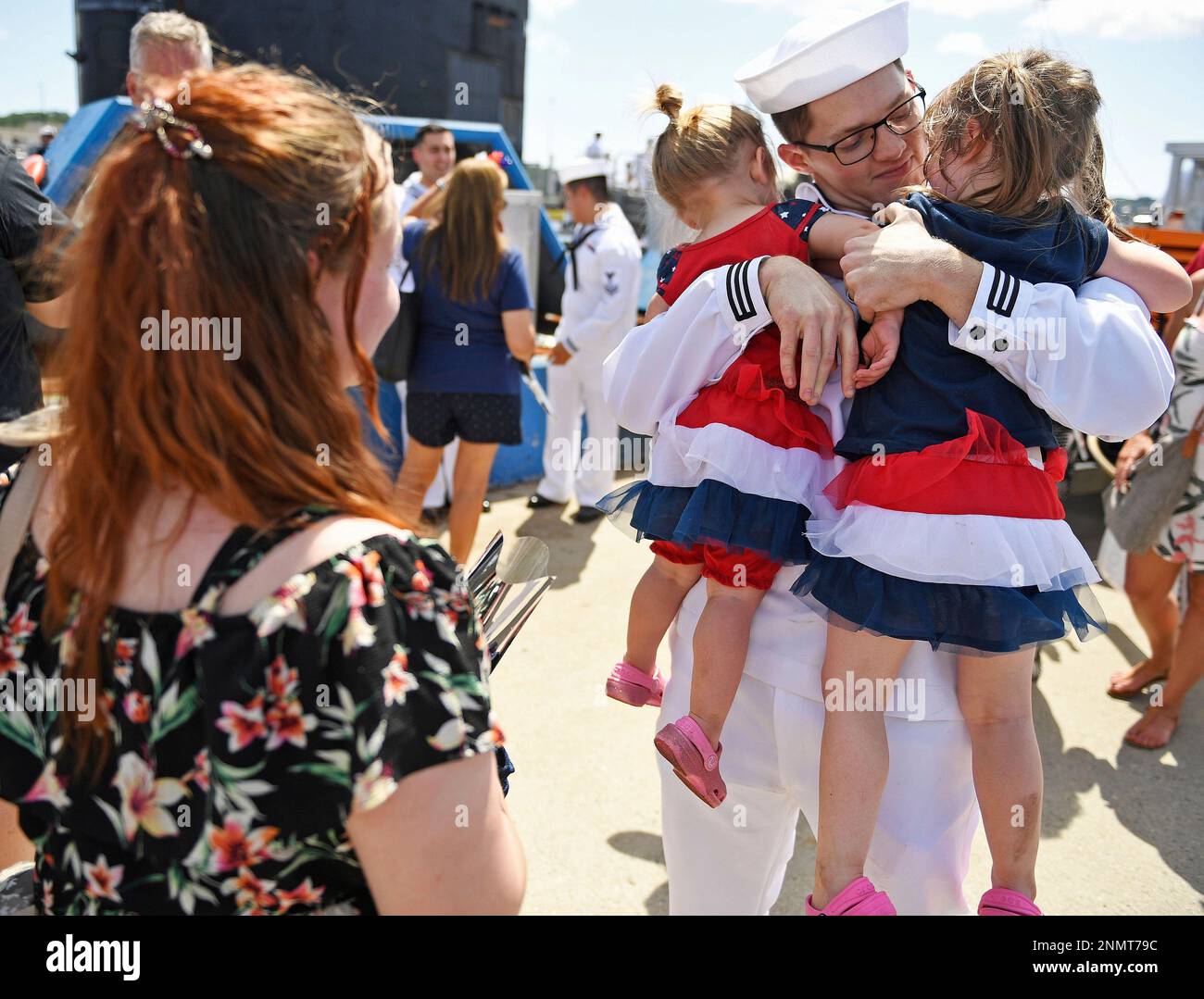 Petty Officer 3rd Class Matthew Crocker embraces his daughters Hadley