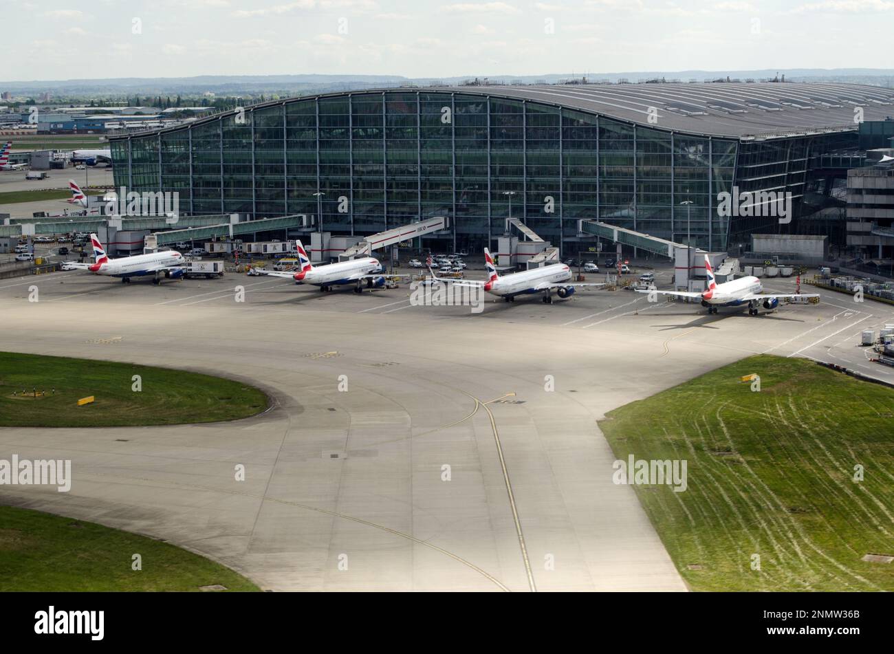 Heathrow, UK - April 26, 2022:  Aerial View of Terminal 5 at Heathrow Airport with British Airways planes awaiting passengers on a Spring afternoon. Stock Photo