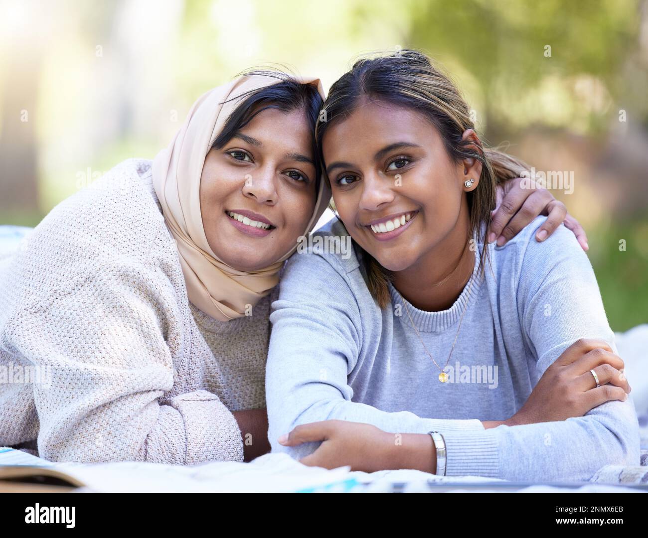 Muslim women, portrait or hug in park, garden or school campus for relax bonding, friends picnic or community support. Smile, happy or Islamic Stock Photo