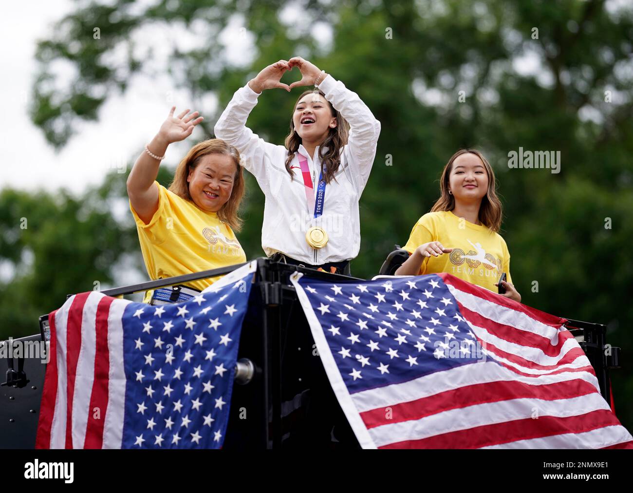 Olympian Sunisa Lee, center, with her mom Yeev Thoj, left