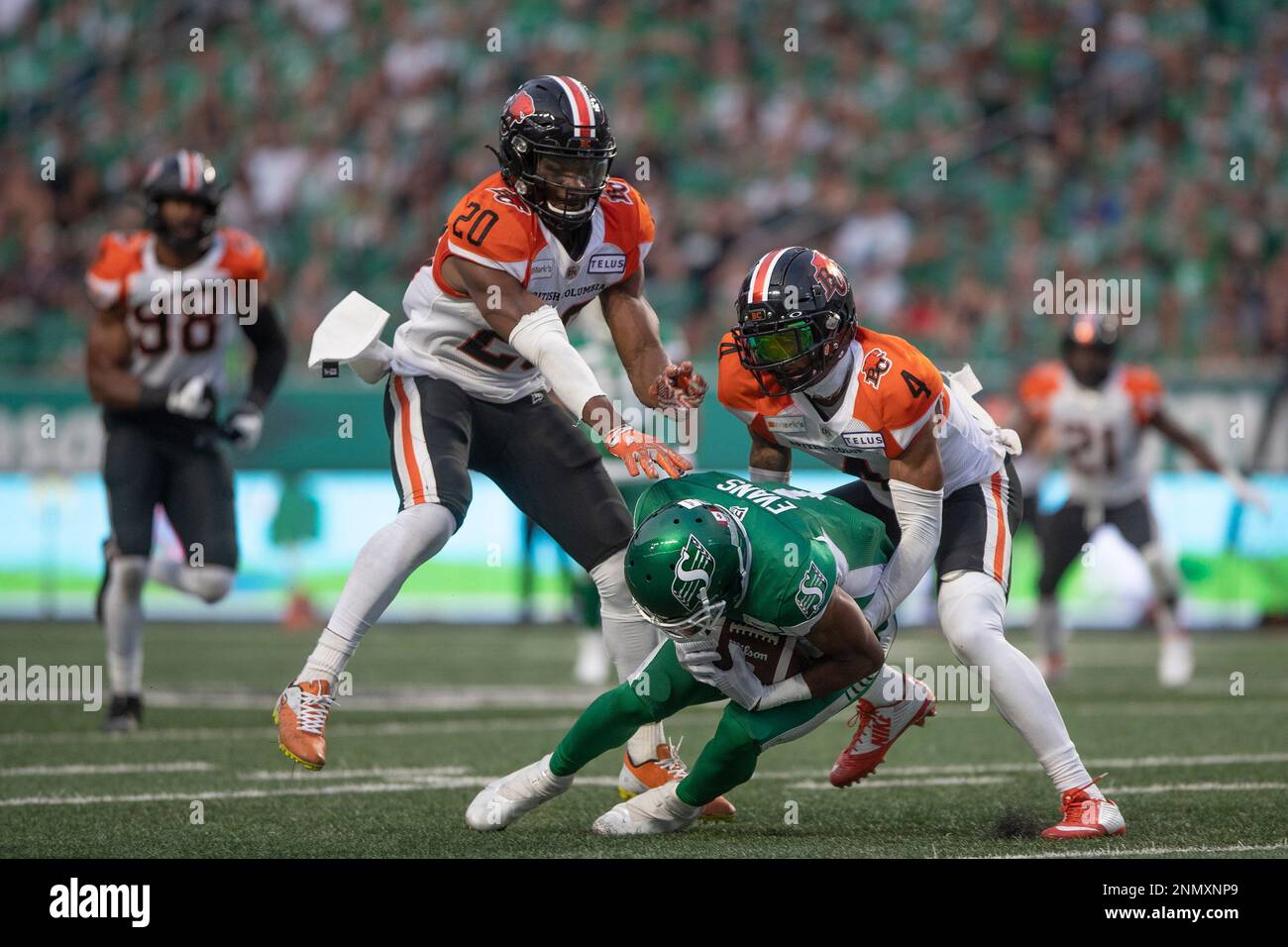 Saskatchewan Roughriders wide receiver Shaq Evans (1) catches the ball as  BC Lions defensive back Garry Peters and BC Lions linebacker Boseko Lokombo  (20) go to make a tackle during the first