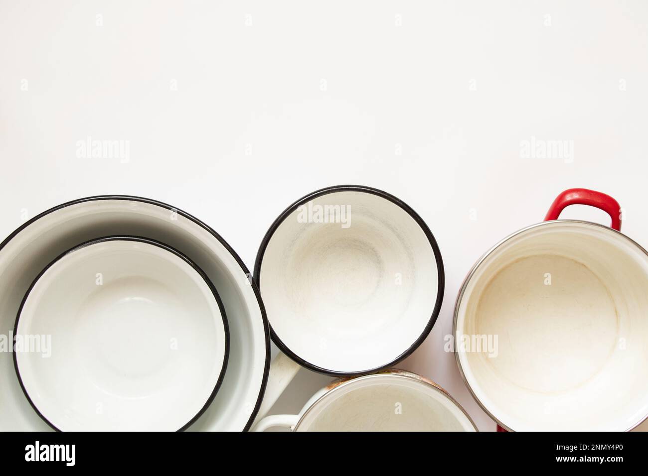Various used enamel kitchen pots on a white background, a set of pots