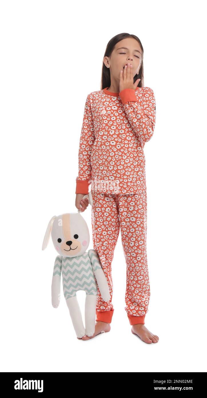 Cute girl wearing pajamas with toy on white background Stock Photo - Alamy