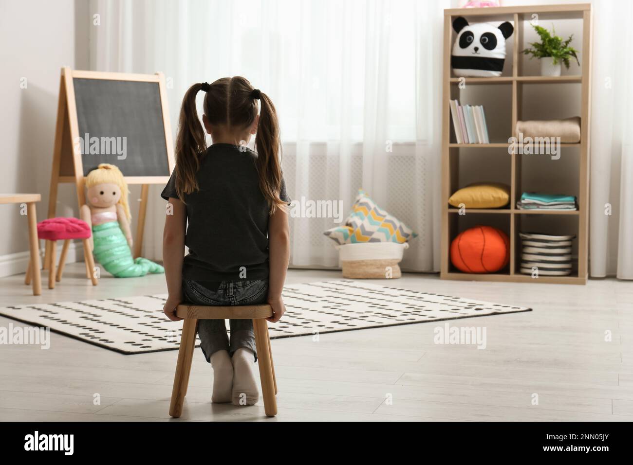 Lonely little girl at home, back view. Autism concept Stock Photo - Alamy