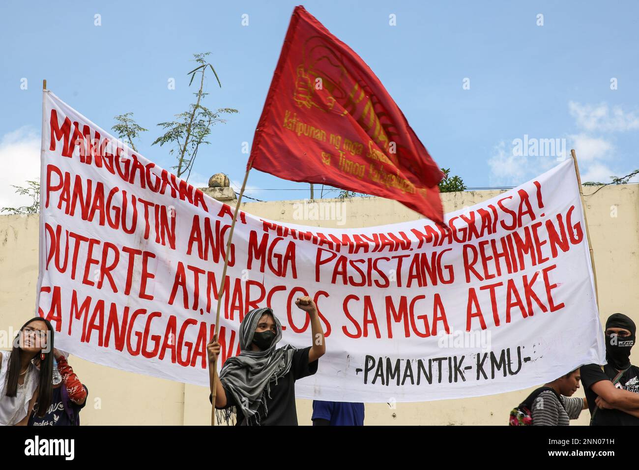 Quezon, Philippines. 25th Feb, 2023. Protesters hold a flag and a banner expressing their opinion during a demonstration. Demonstrators hold a protest in the EDSA People Power monument in celebration of the 37th anniversary of the People Power Revolution. It is also the first People Power Anniversary under Marcos Jr.'s administration. (Photo by Earvin Perias/SOPA Images/Sipa USA) Credit: Sipa USA/Alamy Live News Stock Photo