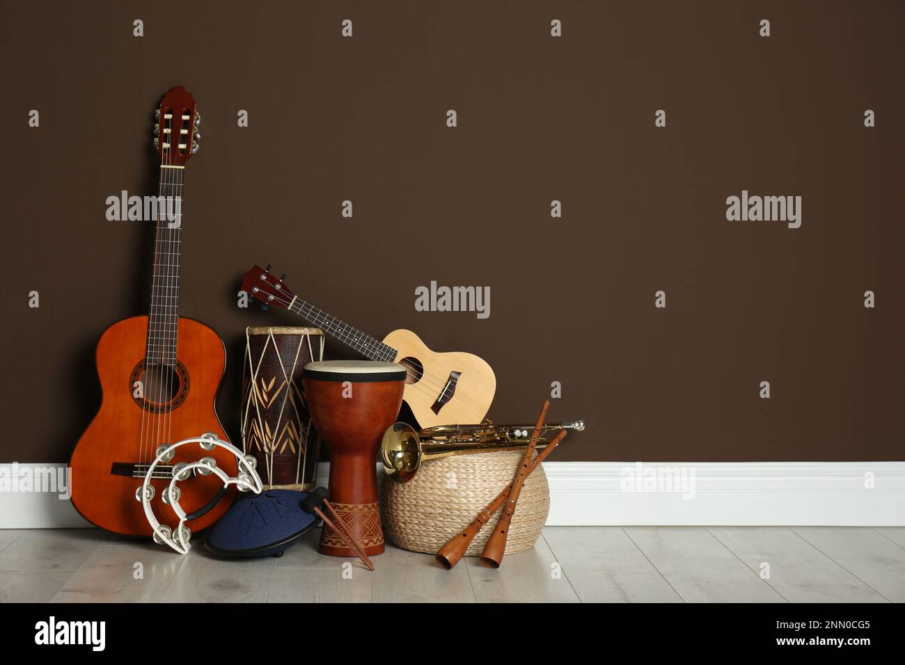 Set of different musical instruments near brown wall indoors, space for ...