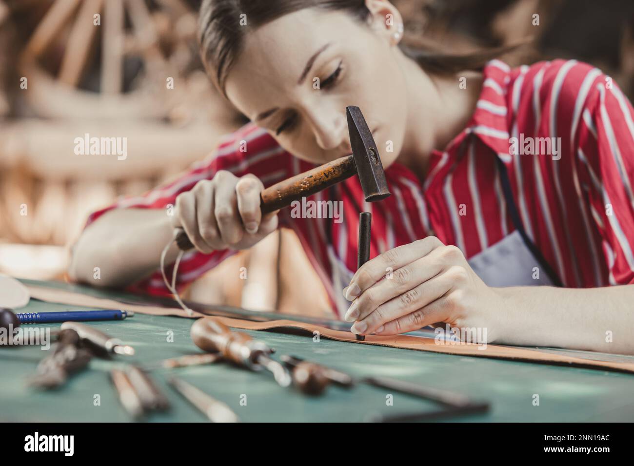 woman leather tailor artist handcraft working at own workshop small studio made by order masterwork piece Stock Photo