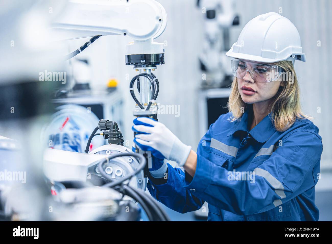 engineer woman worker working with robotic arm in productions lab research industry factory Stock Photo