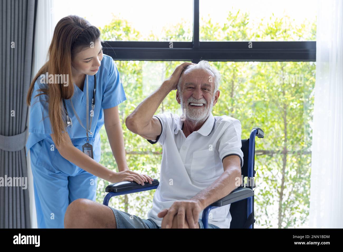 Nurse care elderly senior old man at home retirement people recovery on wheelchair. Stock Photo