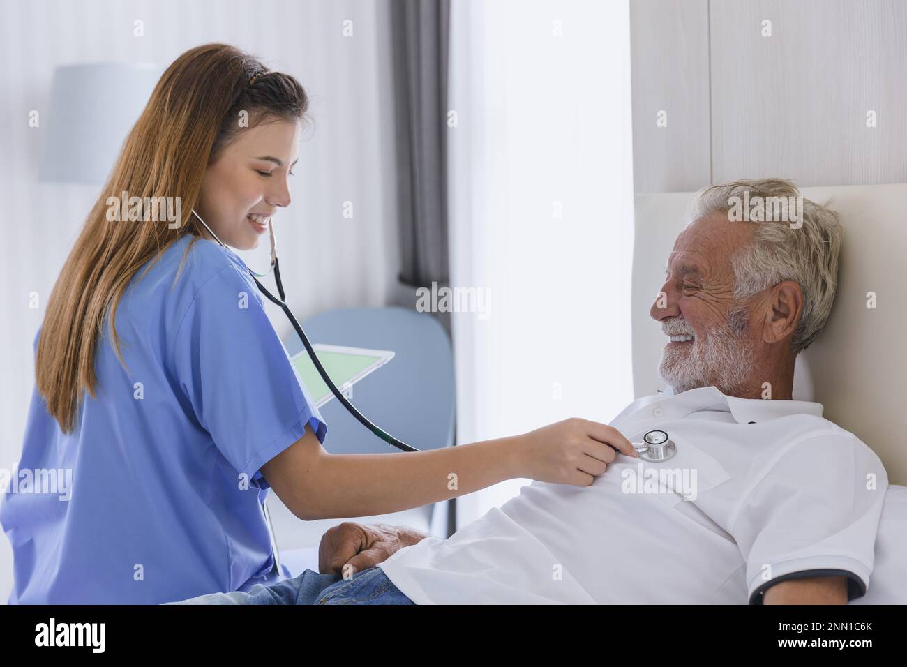 Nurse doctor working at home care medical checkup healthy elderly senior male happy smile Stock Photo