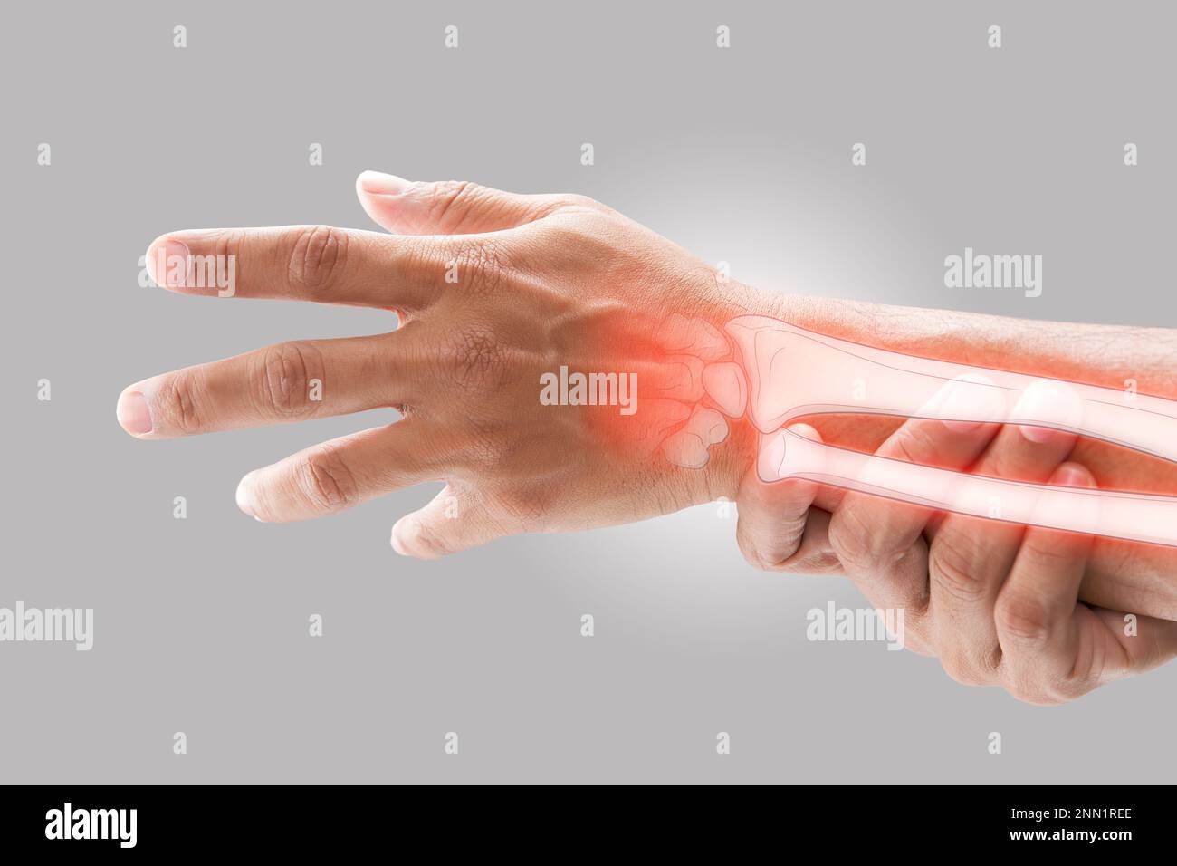A man massaging painful wrist on a gray background. Pain concept. Osteoporosis Stock Photo
