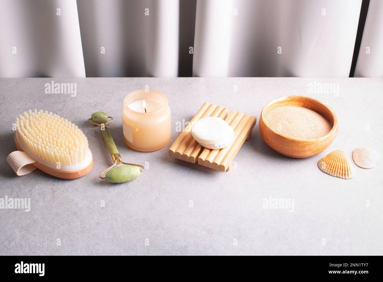 Beauty, self care, wellness, cosmetology products on gray stone table against gray curtains. Day spa, relaxation concept. Stock Photo