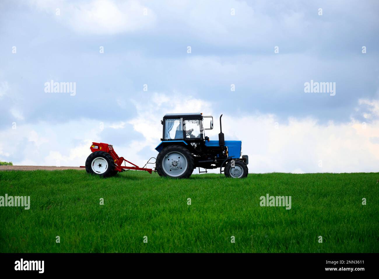 NEIGHBORHOOD TELENESTI, MOLDOVA - MAY 2019: Driver wheeled tractor fertilizing winter wheat with mineral fertilizers. Feeding of grain crops. Rural la Stock Photo