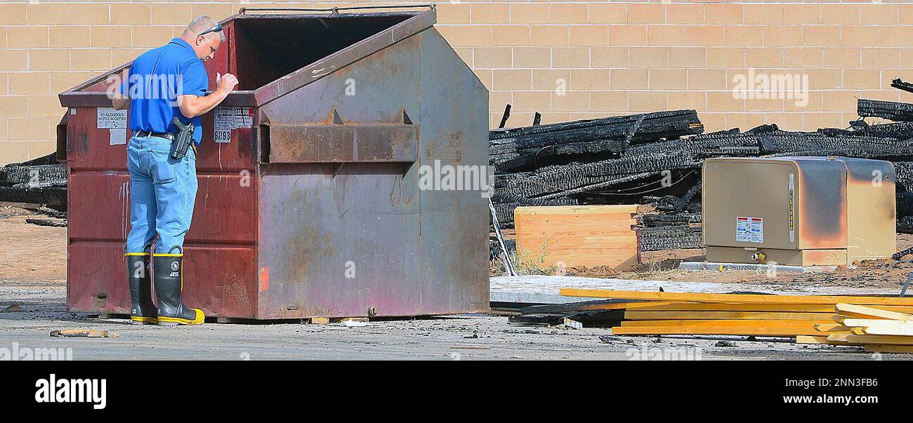 Yuma Police Department Det. Josh Peterson checks a dumpster Thursday, June 10, 2021 for clues to