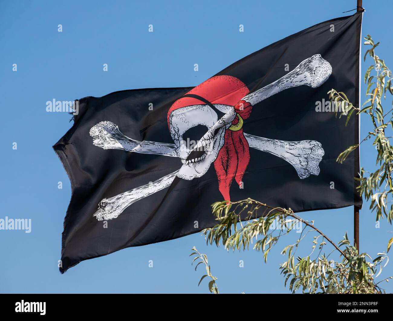 A skull and cross bones pirate flag waving in the wind. Stock Photo