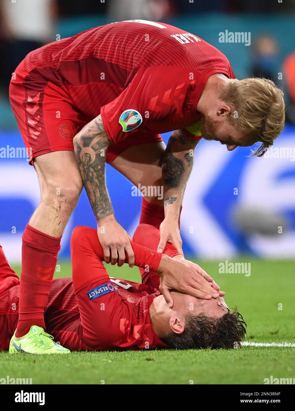Denmark's Simon Kjaer, up, checks on Denmark's Jannik Vestergaard ...