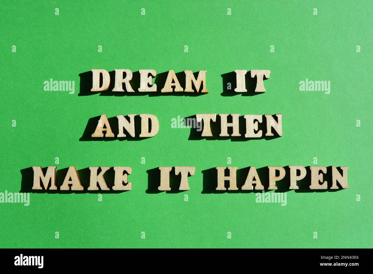 Dream It And Then Make It Happen, motivational words in wooden alphabet letters isolated on bright green background Stock Photo