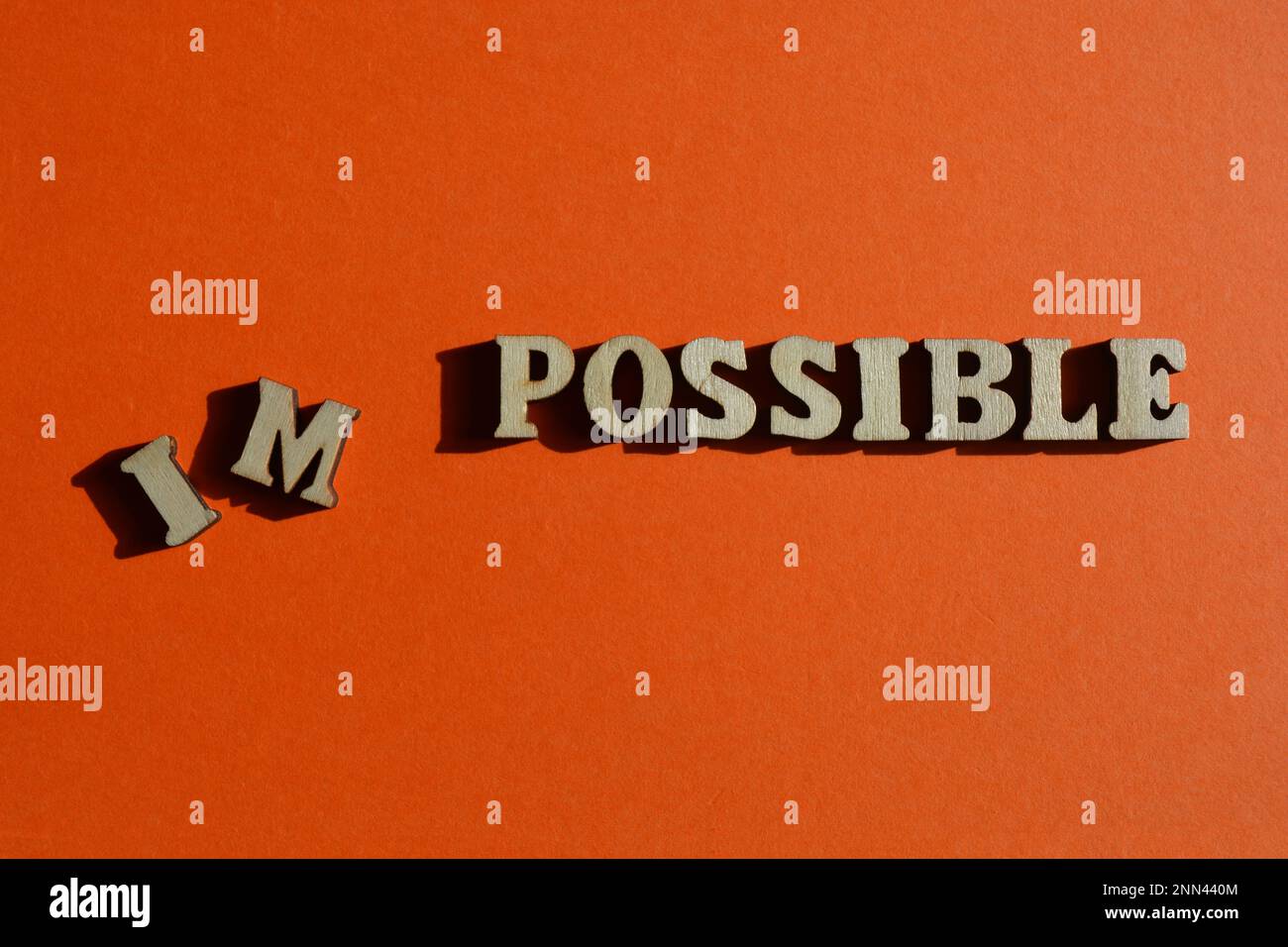 Impossible, Possible, words in wooden alphabet letters isolated on bright orange background Stock Photo