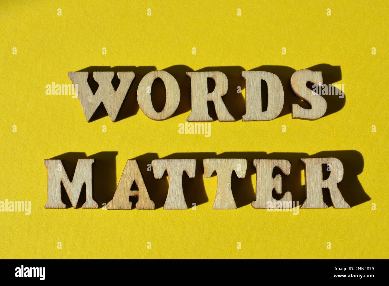 Words Matter, phrase in wooden alphabet letters isolated on yellow background Stock Photo