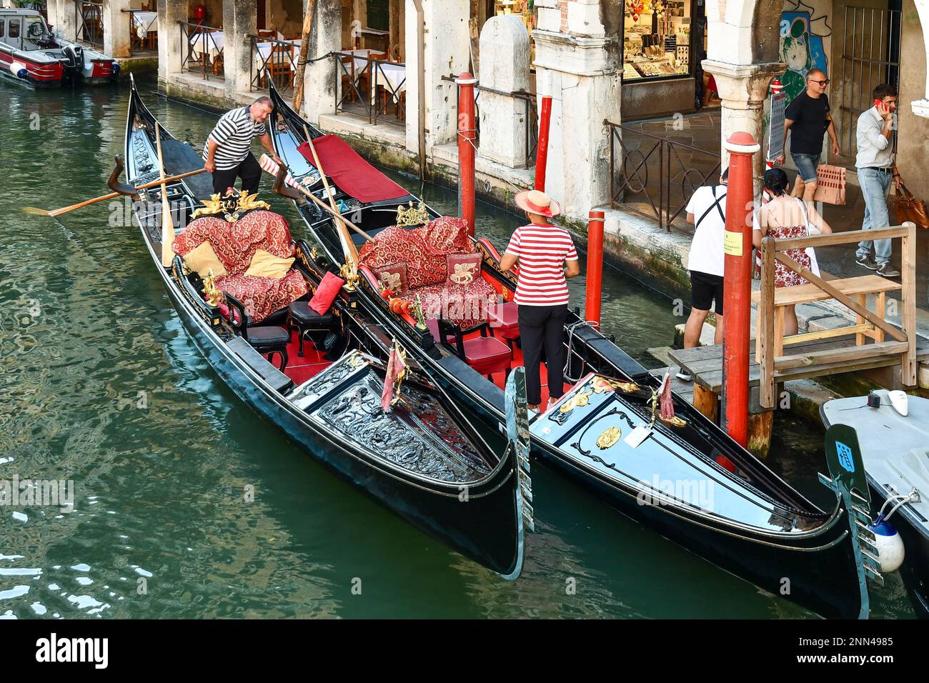 Gondoliers waiting for tourists on the Rio dei Santi Apostoli canal in the sestiere of Cannaregio in summer, Venice, Veneto, Italy Stock Photo