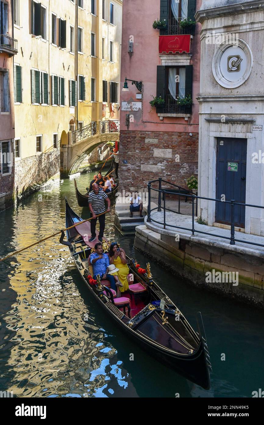 Gondolas with tourists on Rio dei Fuseri canal with the Ponte de le Colonne in the background, St Mark's district, Venice, Veneto, Italy Stock Photo