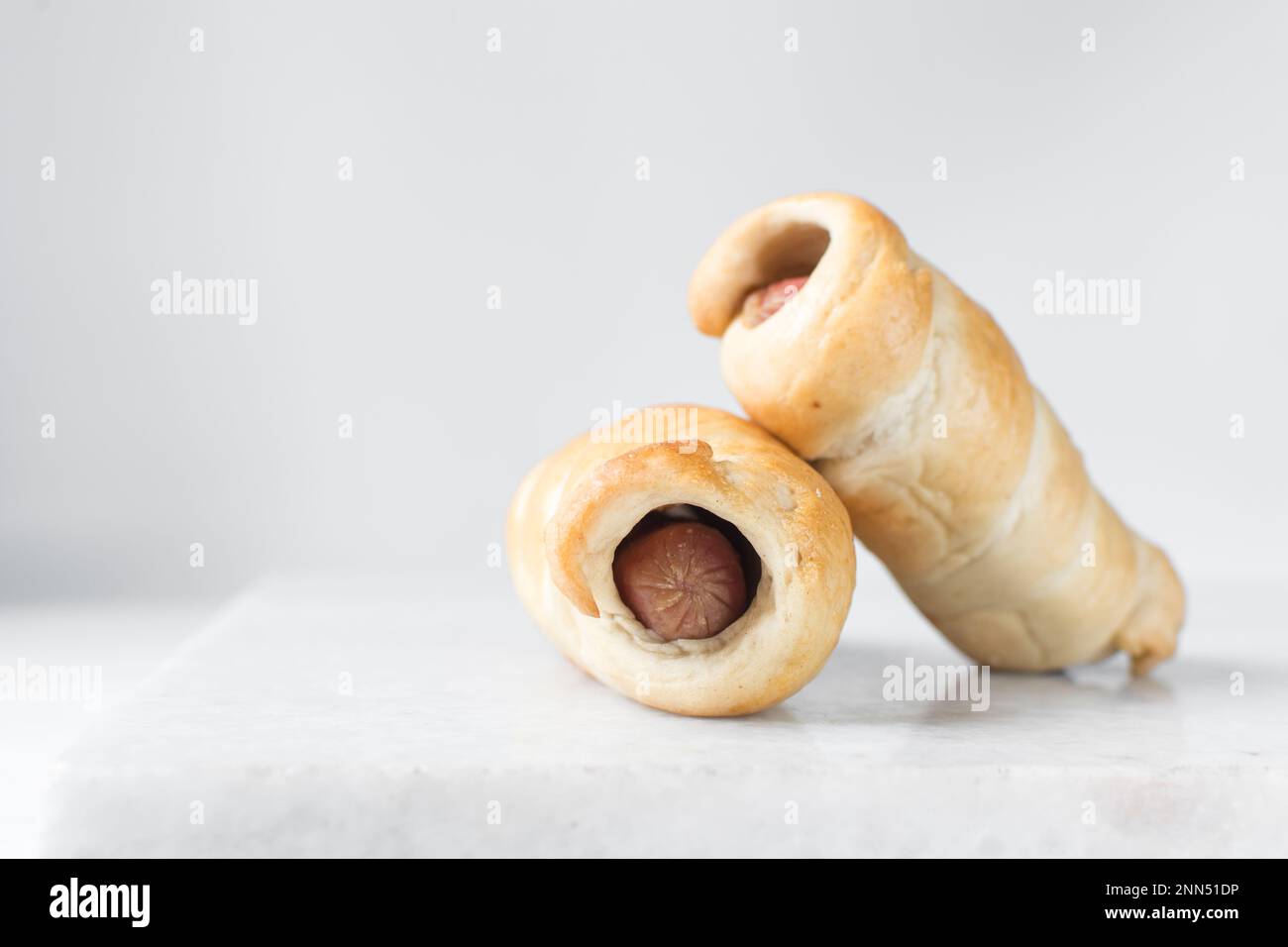 Sausage roll on a marble tray, twisted sausage roll on a marble tray, Large pigs in a blanket
