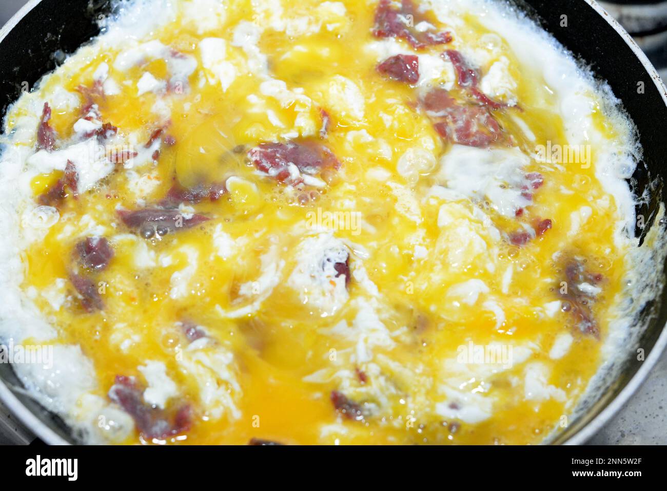 Scrambled eggs with pastrami, a dish made from eggs stirred, whipped or
