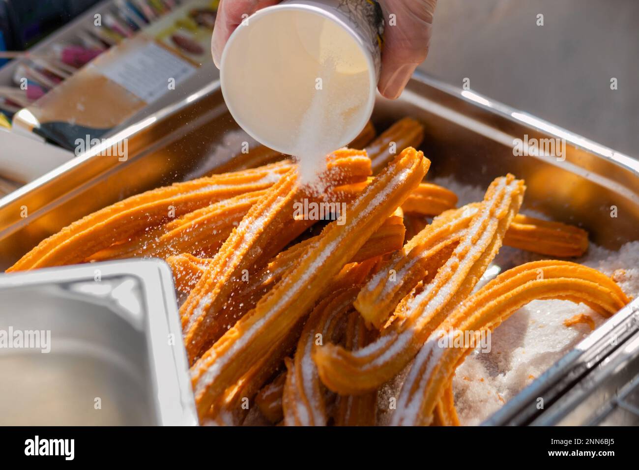 Chef preparing homemade crunchy churros at street food market close up